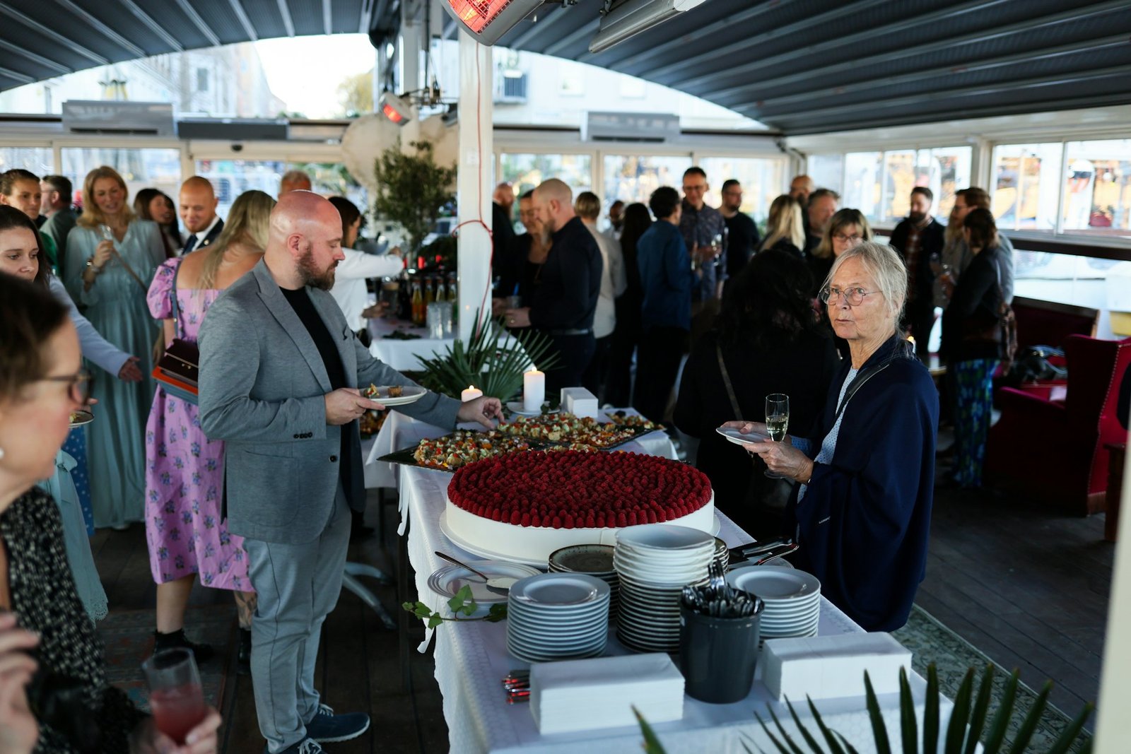 Guests gathered around a dessert buffet with a celebration cake