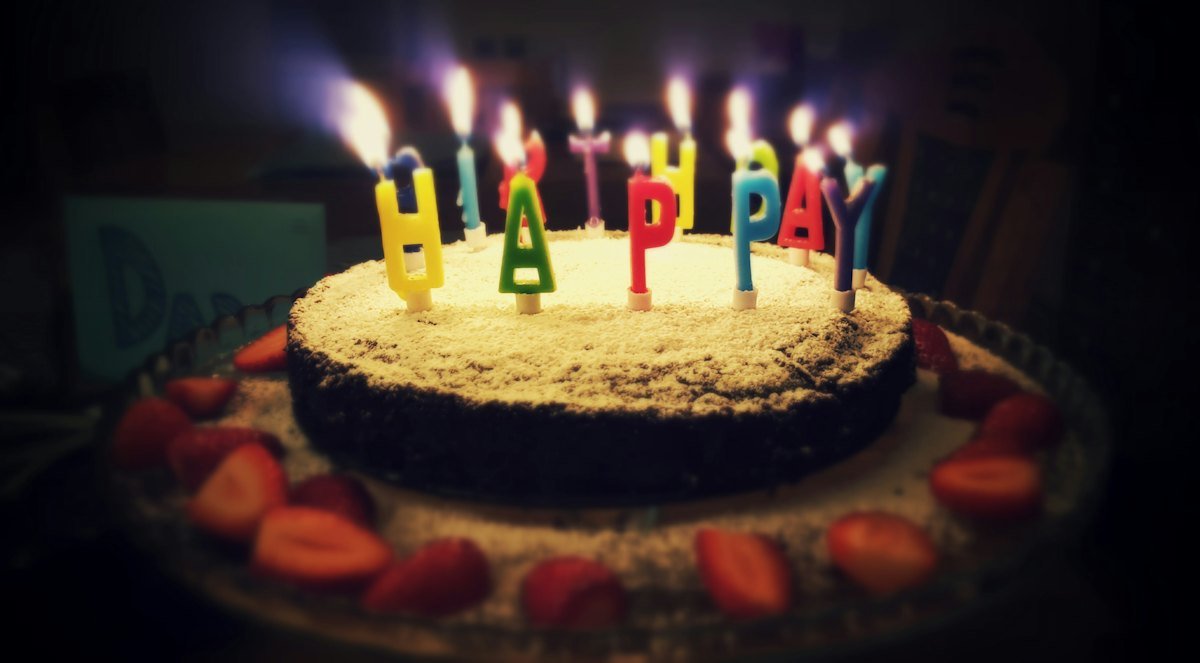 A birthday cake with its candles lit, waiting for the cake-cutting moment