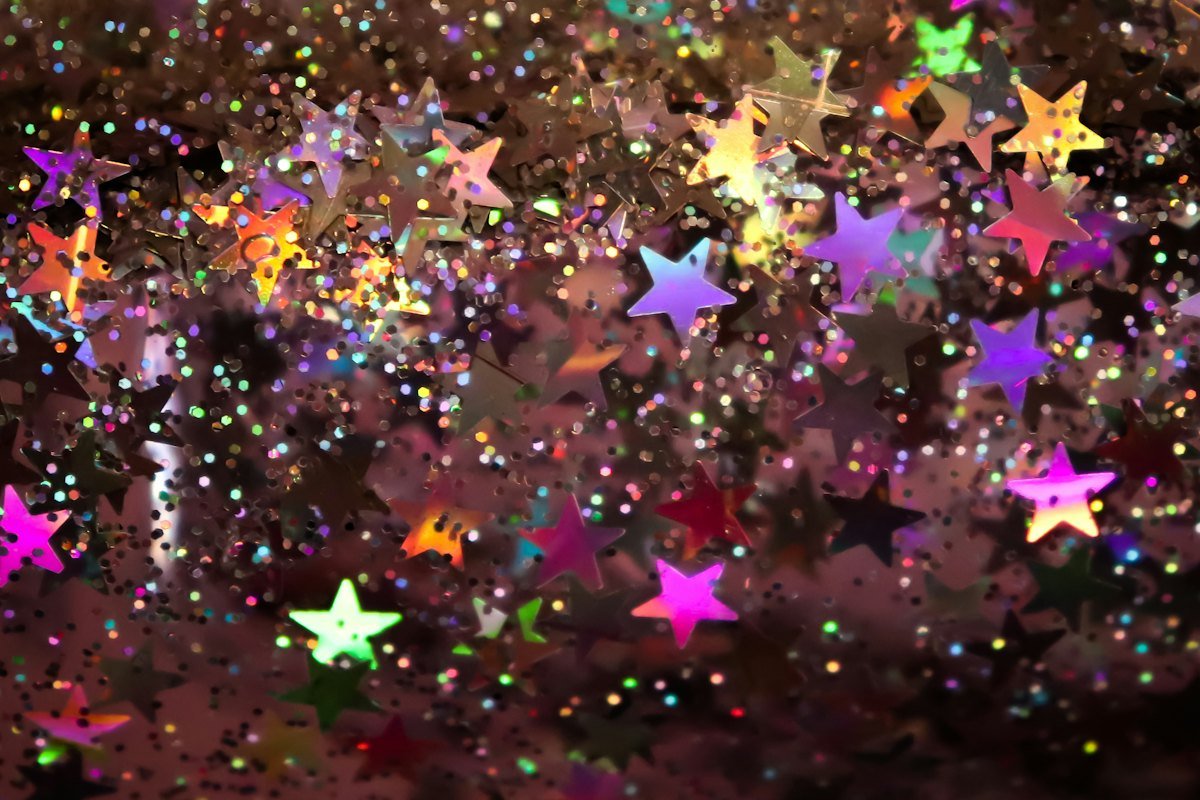 Golden glitter and sequins catching the light as birthday wishes are shared